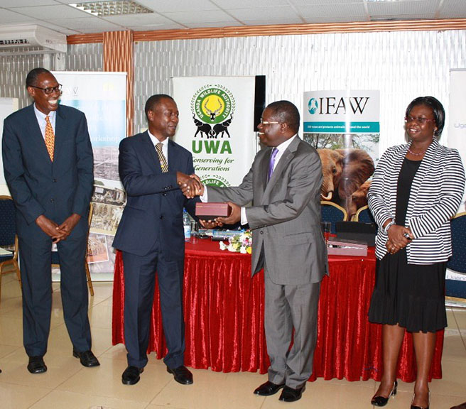 James Isiche, Regional Director IFAW, EA presents an appreciation gift to Richard Kamajugo, Commissioner of Customs at URA.