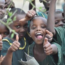Smiling children giving a thumbs up