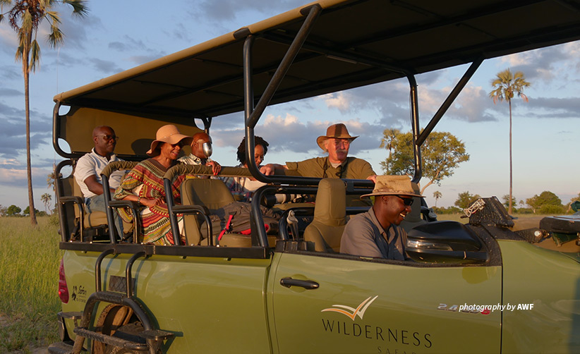 Photo of AWF staff and business leaders in safari vehicle