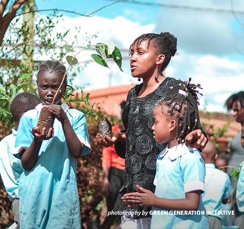 Photo of climate activist Elizabeth Wathuti planting trees with school children