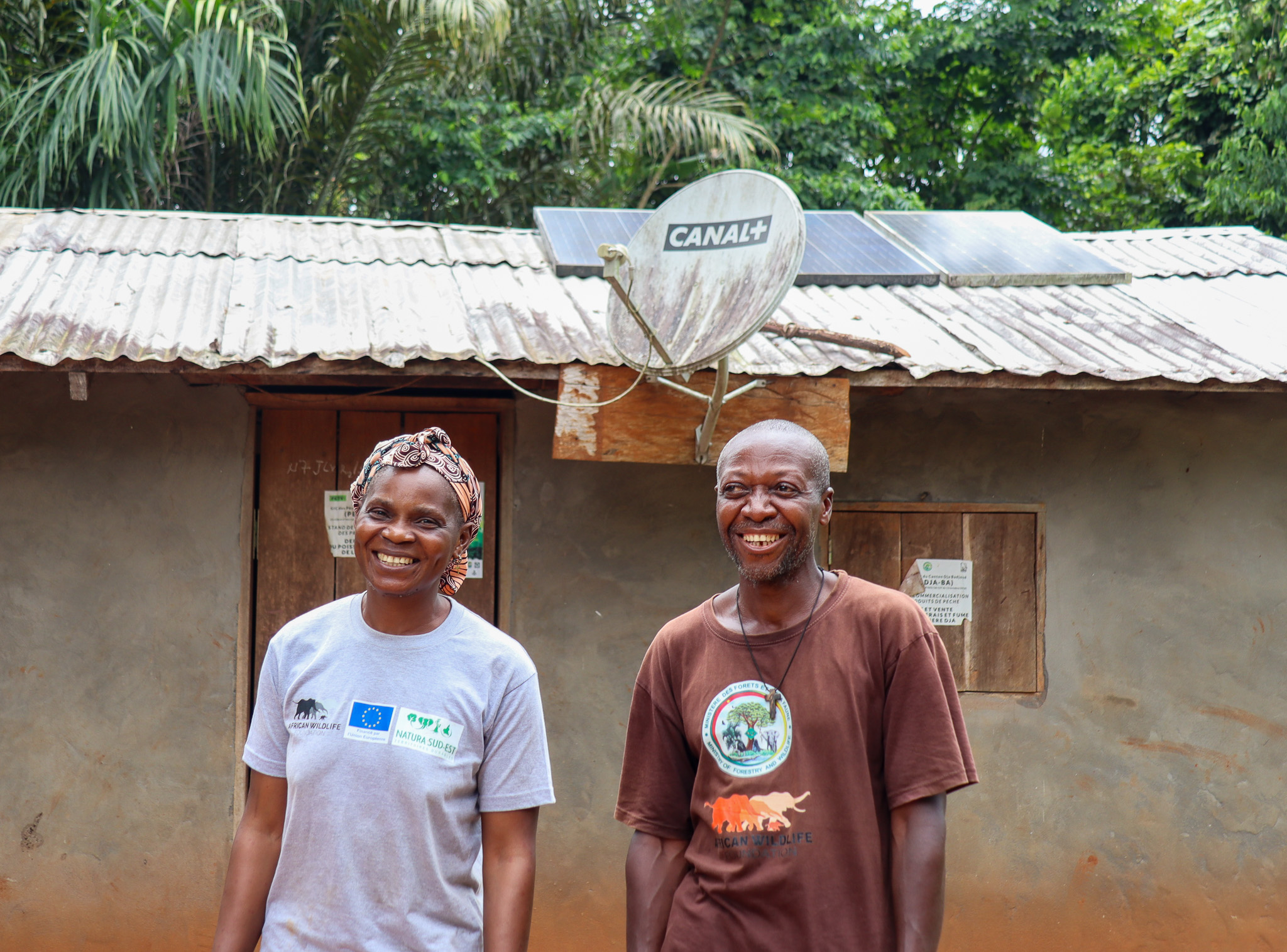 Clautilde and Sere Etienne stand infront of their Solar powered home, Dja, Cameroon.
