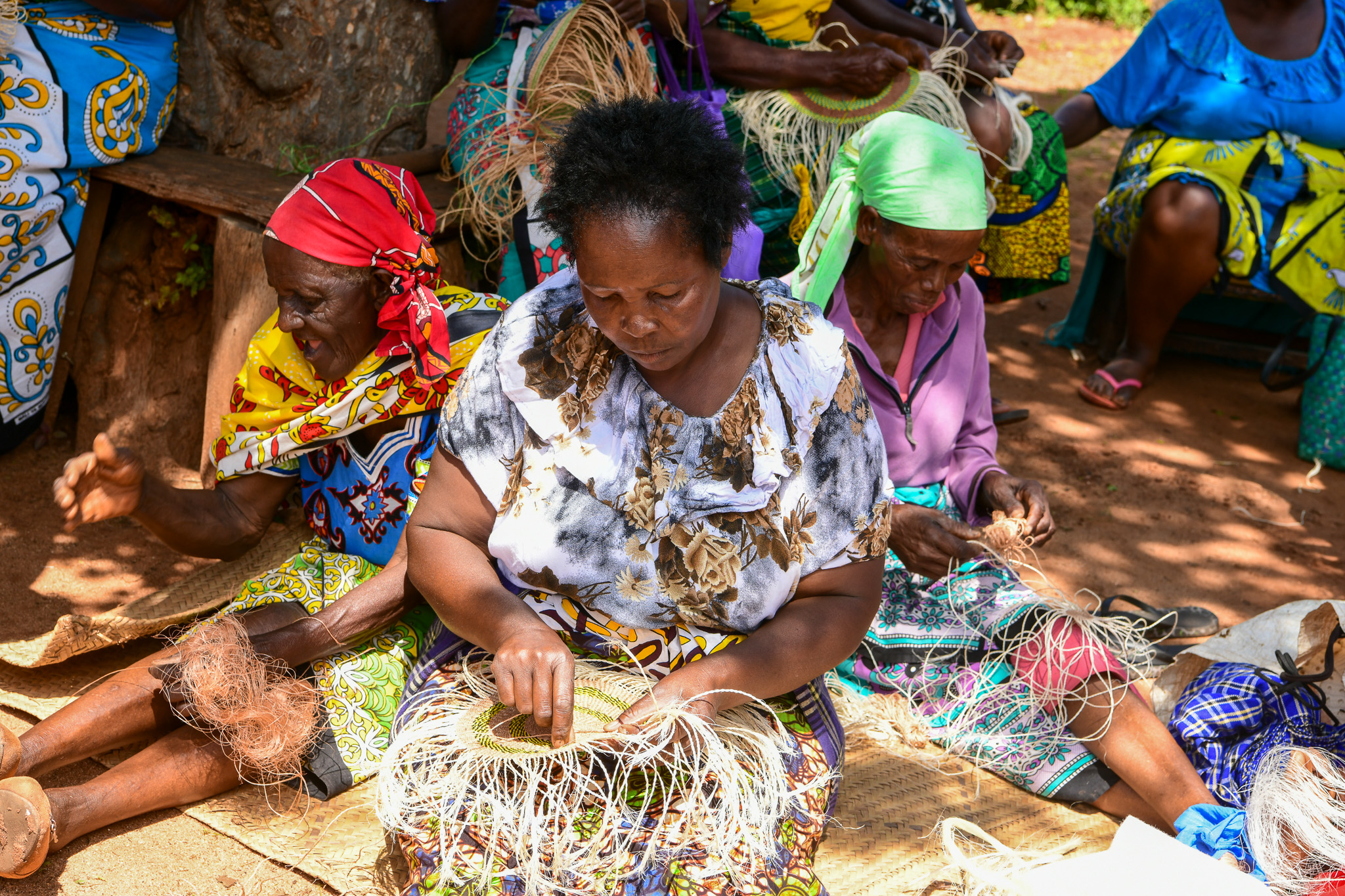 Local women in Taita Taveta County engaging in basket weaving at a communal meeting point.