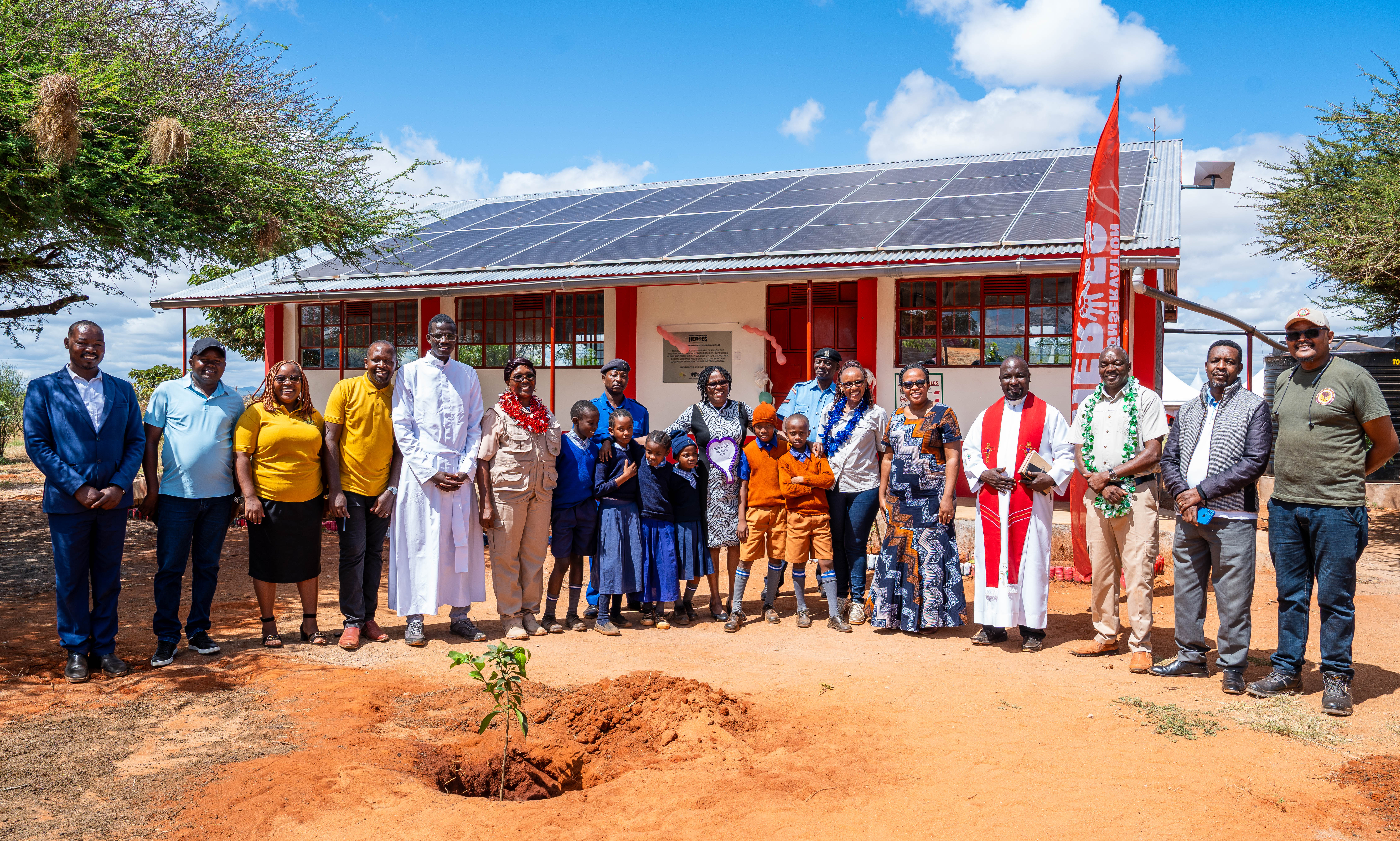 Nancy Githaiga, AWF Kenya Country Director, with partners and students in front of the solar-powered ICT lab following its official launch.