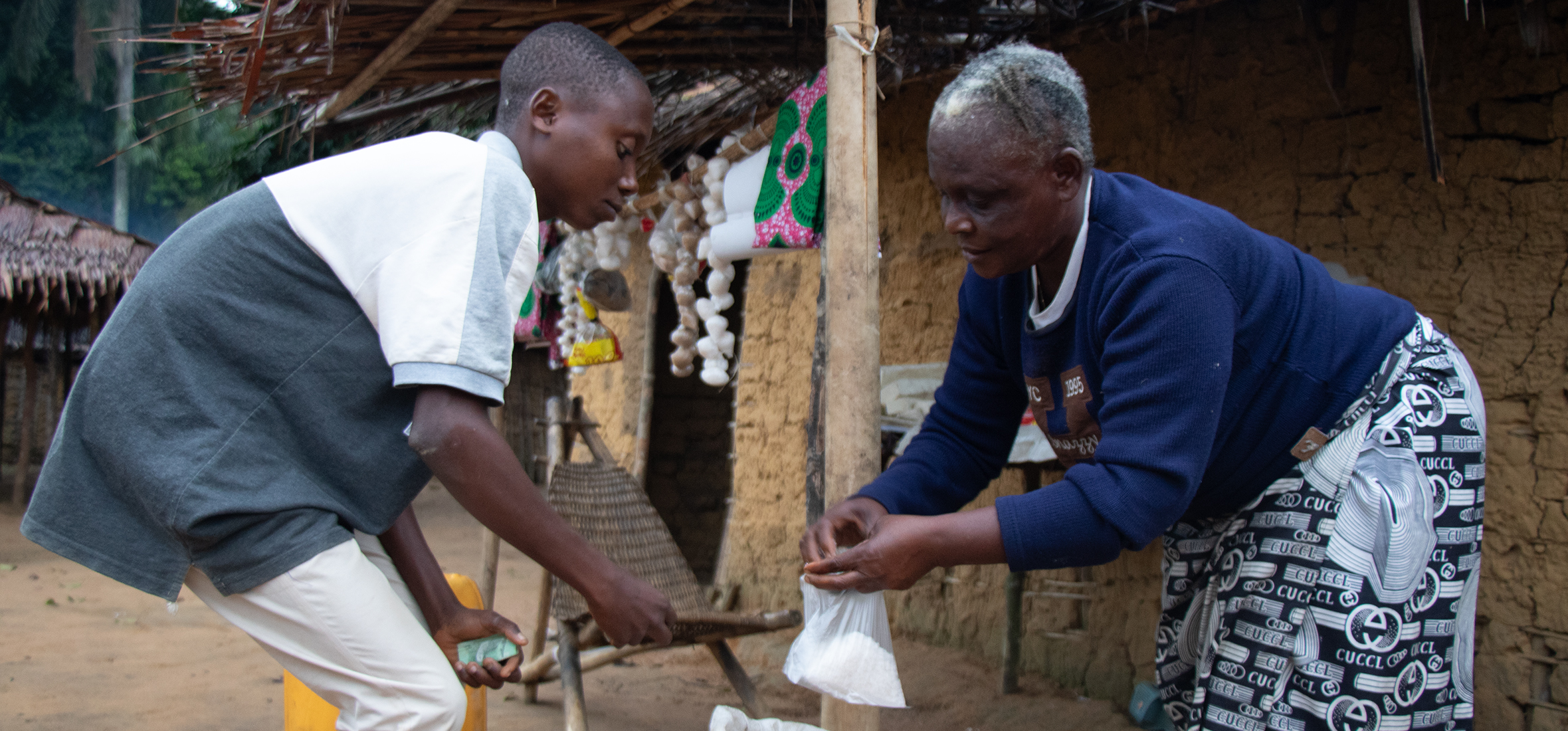 Bokeso Ekongo Marceline, a beneficiary, makes a final sale of salt to a customer before nightfall.
