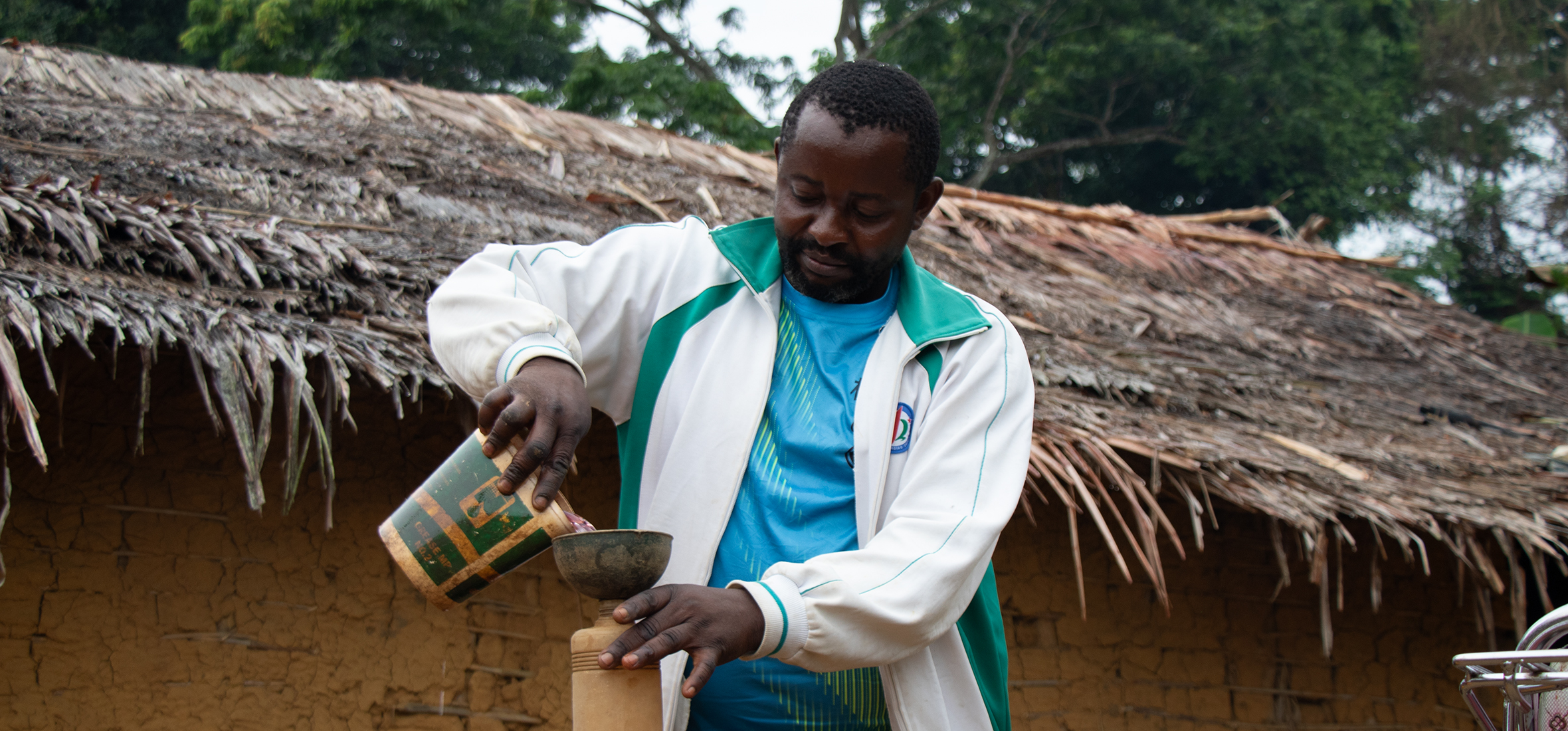 Yango Bonsonga Thithi carefully measures fuel for a customer.