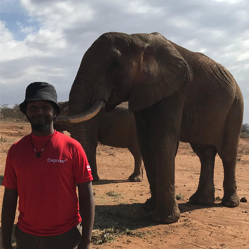 Isaac Mureithi poses in front of an elephant at Ol Jogi Wildlife Conservancy.