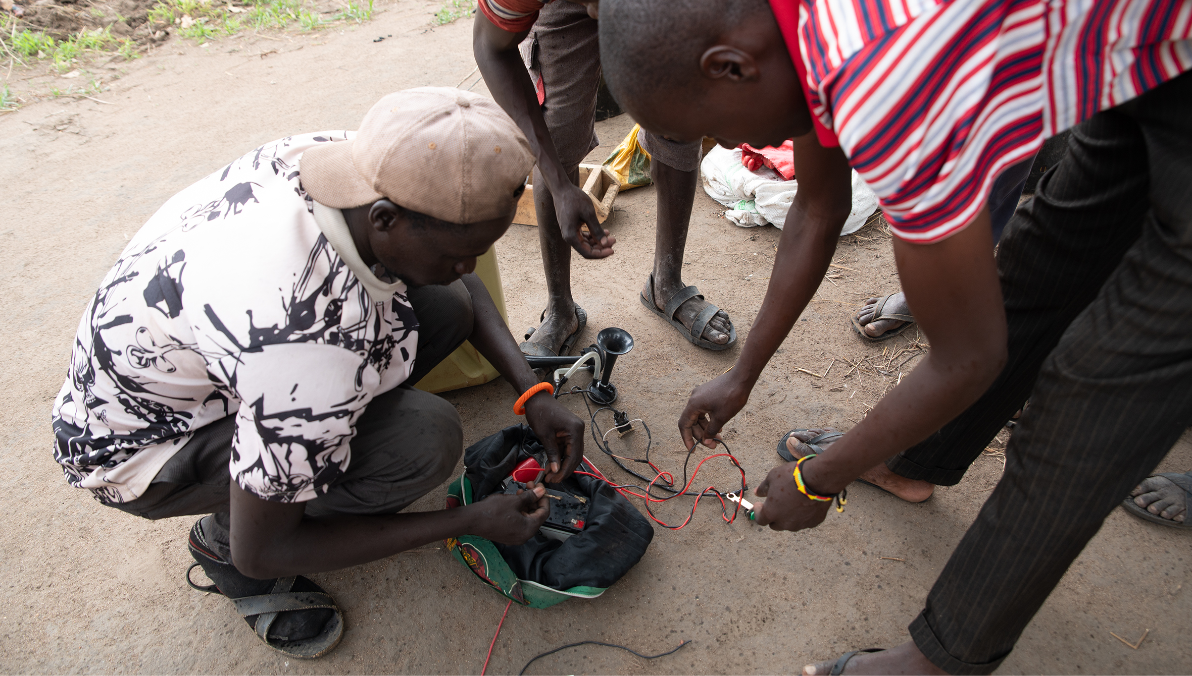 Community wildlife scouts assemble a portable electric horn used to produce loud sounds which deter elephants from entering nearby farms. 