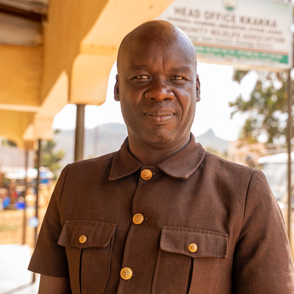 Abach Peter, Administrator of KKAKKA Community Wildlife Association, poses for a photo in the Kidepo Landscape.
