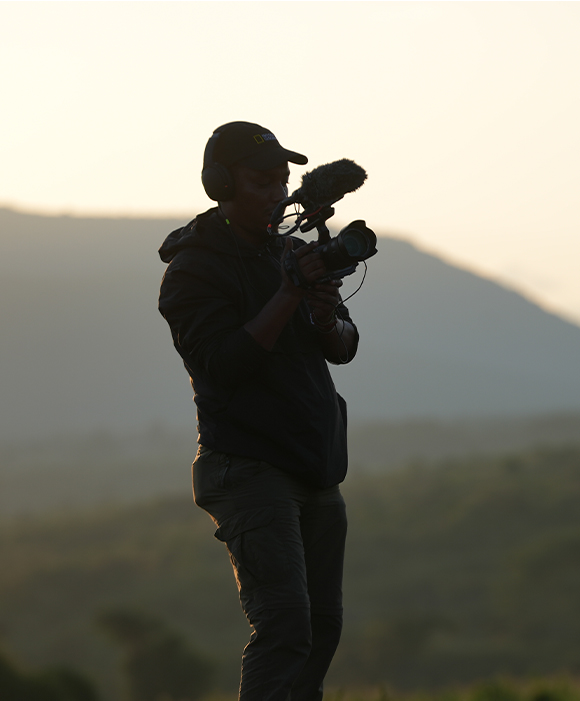 Photographer stands silhouetted against a twilight sky