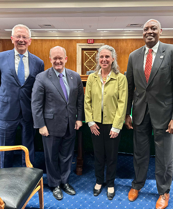 Senator Chris Coons, Kaddu Sebunya, and two others