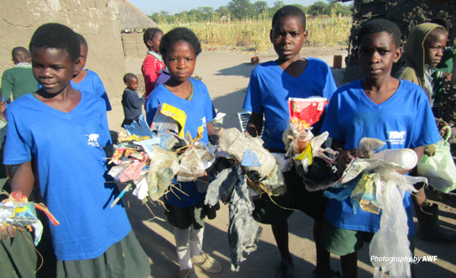 Photo of primary school children at Classroom Africa Lupani School picking litter Photo of primary school children at Classroom Africa Lupani School picking litter