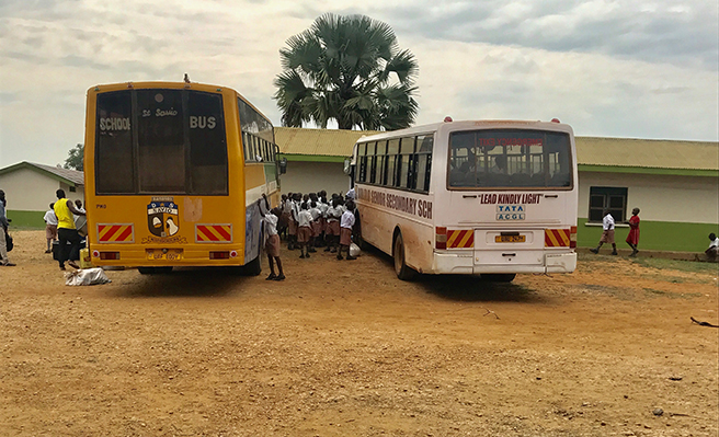 Photograph of children boarding buses for a field trip in Uganda Murchison Falls
