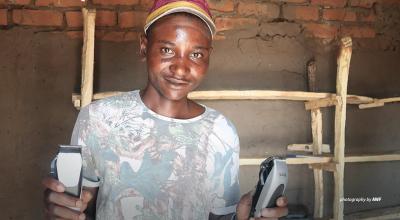 Portrait of wildlife scout Desire Chisunga holding hairdressing equipment