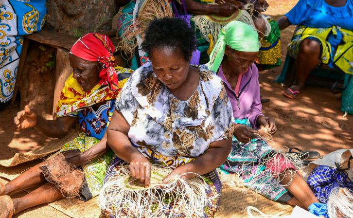 Local women in Taita Taveta County engaging in basket weaving at a communal meeting point.