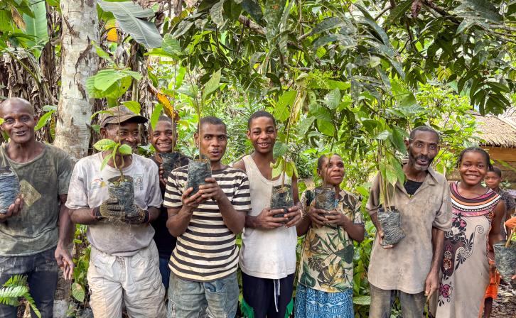 Bagyeli Indigenous community members holding cocoa plants received from AWF through FEDEC funding for planting in their farms alongside their rubber plantations. 