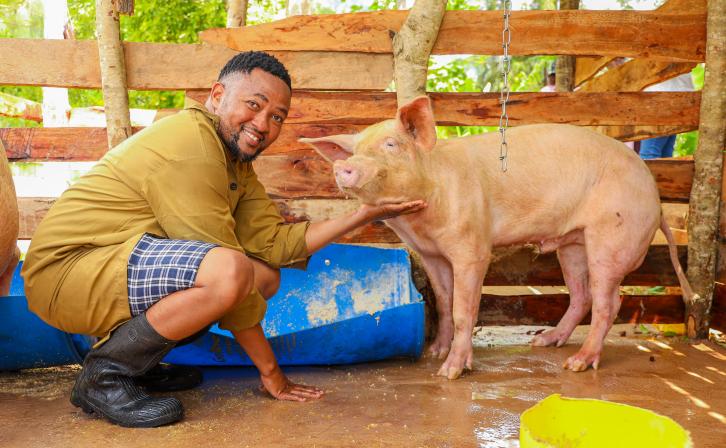 Hedlam Toli posing for a photo with his pig.