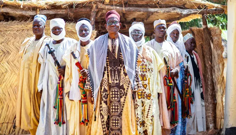Hayatou Adji, traditional ruler of Voko, stands in front of his palace with members of his council.
