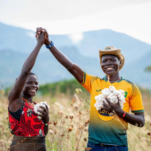 Cotton farmers Victor Bari and Hellen Nakwang celebrating the harvest on their farms.
