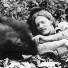 Black-and-white photo of Craig Sholley with an ape.