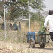 Young boy pushing a barrel of water from the Rural Resource Center in Tchamba