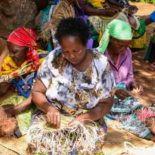 Local women in Taita Taveta County engaging in basket weaving at a communal meeting point.