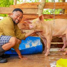 Hedlam Toli posing for a photo with his pig.