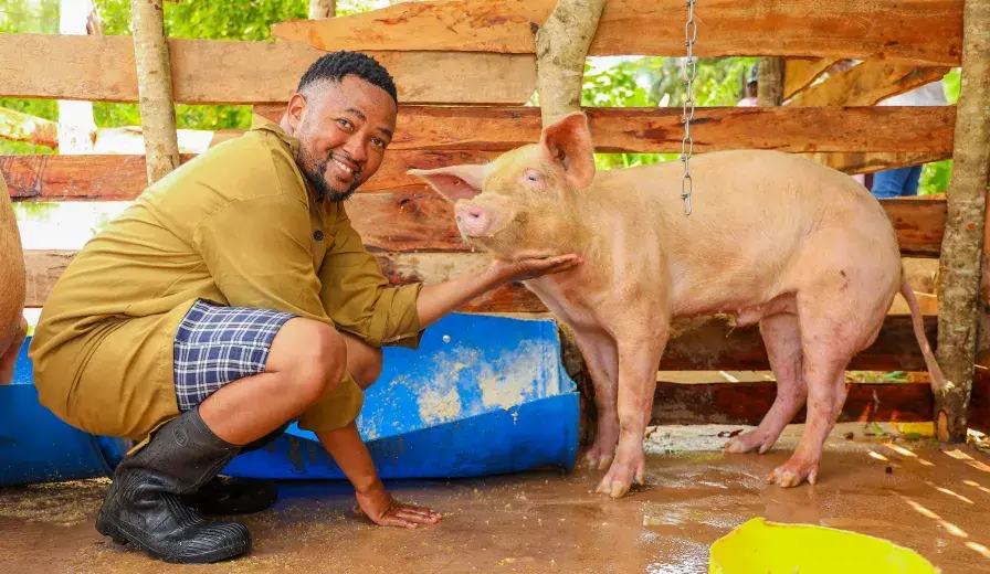 Hedlam Toli posing for a photo with his pig.
