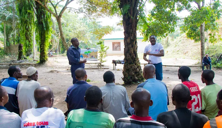 Dodo Moke, AWF Senior Social Safeguards Officer, discusses rights-based conservation with community members in Ilima, DRC.