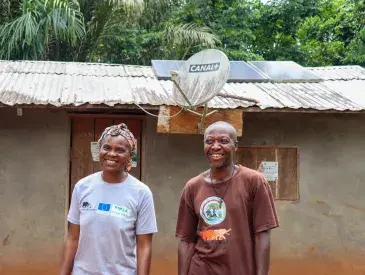 Clautilde and Sere Etienne stand infront of their Solar powered home, Dja, Cameroon.