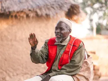 Papa Gambo sitting outside his house