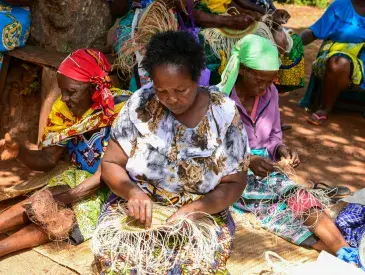 Local women in Taita Taveta County engaging in basket weaving at a communal meeting point.