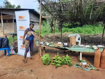 A Bagyeli Indigenous woman displays medicinal plants and harvested crops.