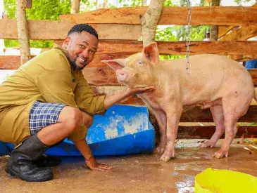 Hedlam Toli posing for a photo with his pig.