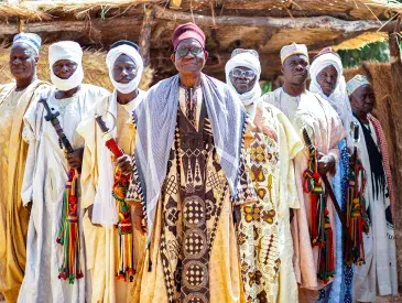 Hayatou Adji, traditional ruler of Voko, stands in front of his palace with members of his council.