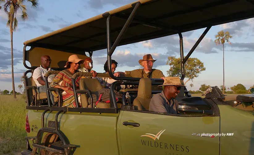 Photo of AWF staff and business leaders in safari vehicle
